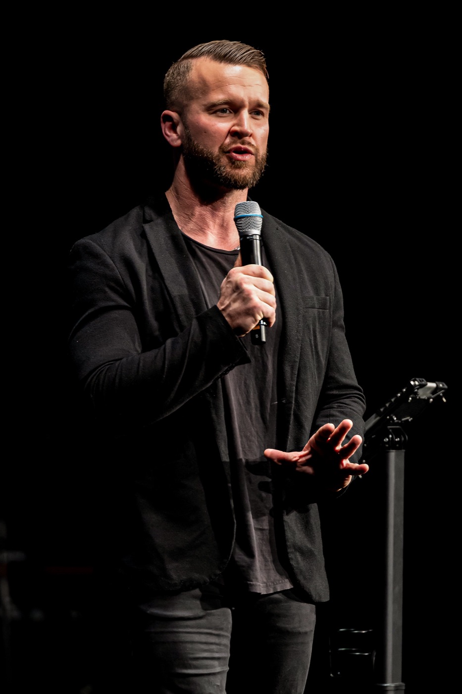 Tyler speaking on stage with a microphone