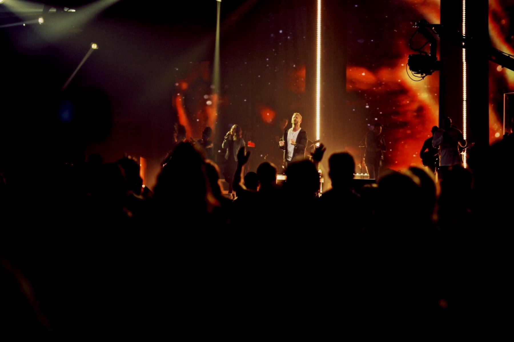 A worshipping crowd before a lit stage
